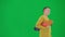 Portrait of boy on chroma key green screen. Schoolboy kid in casual walking with skateboard in hands, greeting friends