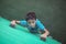 Portrait of boy climbing green wall