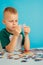 Portrait of a boy connecting puzzles.on a blue background