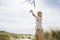 Portrait Of Boy Flying Kite On A Windy Beach