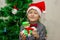 Portrait of a boy with funny glasses and christmas toys decorating cristmas tree and have fun