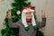 Portrait of a boy with funny glasses and christmas toys decorating cristmas tree and have fun