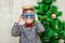 Portrait of a boy with funny glasses and christmas toys decorating cristmas tree and have fun