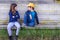 Portrait of boy and girl sitting in the street of suburb