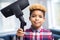 Portrait Of Boy Helping Out With Chores At Home Holding Vacuum Cleaner