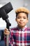 Portrait Of Boy Helping Out With Chores At Home Holding Vacuum Cleaner