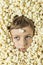 Portrait of a boy with his face surrounded by popcorn