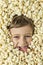 Portrait of a boy with his face surrounded by popcorn