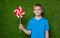 Portrait of a boy holding pinwheel over grass