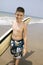 Portrait of boy holding surfboard on beach