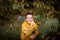 Portrait of a boy in hoodie posing with bunch of autumn leaves. Copy space