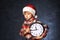 Portrait of a boy in the image of Santa with a clock indicating the time before Christmas