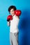 Portrait, boy and kid with boxing gloves, fitness and confident fist on a blue studio background. Child development