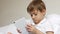 Portrait of a boy looking at the tablet screen and touching the touch screen with his fingers. The child uses the tablet