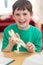 Portrait Of Boy Making Model Dinosaur At Home