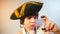 Portrait of a boy in a pirate costume, wearing a hat on his head.