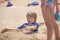 Portrait of a boy playing on the beach buried in the sand