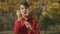 Portrait of the boy in red shirt blowing a soap bubble in the park. Child is playing outdoors.