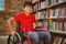 Portrait of boy sitting in wheelchair at library