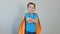 Portrait of a boy in a superhero costume hugs himself with his hands. success concept. happy childhood. 4k video