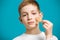 Portrait of a boy tearing off adhesive plaster from his che