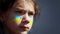 Portrait of a boy with the Ukrainian flag on the face of body painting.