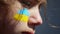 Portrait of a boy with the Ukrainian flag on the face of body painting.