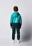 Portrait boy in warm tracksuit, sneakers back view