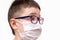 A portrait of a boy wearing surgical medical face mask and glasses on white background, antiviral protection concept