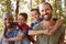 Portrait Of Boys With Fathers On Hiking Adventure Through Forest