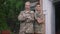 Portrait of brave confident military mother and teenage son in khaki camouflage crossing hands smiling looking at camera