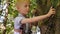 Portrait of a brave little boy in a rope Park in the summer, he holds a carbine.