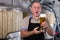 Portrait of brewer who is standing with glass of beer on his workplace