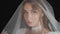 Portrait of bride face close-up under veil. Girl touching her veil. Wedding morning preparations before ceremony