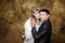 Portrait of bride and groom hugging on hay at stable