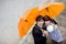 Portrait of bride and groom with orange umbrellas