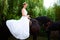 Portrait of a bride on horseback on the background of a summer s