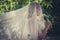 Portrait of bride with veil and bouquet of wild flowers outdoor