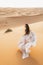 Portrait of bride woman in amazing wedding dress in Sahara desert dunes, Morocco