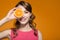 Portrait of a bright smiling positive young woman with oranges in her hands. Orange background