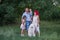 Portrait of bright, unusual, diversity family in nature with Samoyed dog. Traveling with pets