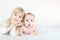 Portrait of brother and sister. Two cute children lying on bed. Open-eyed surprised or astonished expression. Brother and sister