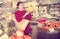 Portrait of brunette girl buying ripe bananas in supermarket