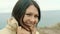 Portrait of a brunette girl looking at the camera on the background of the sea