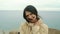 Portrait of a brunette girl looking at the camera on the background of the sea