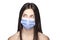 Portrait of a brunette girl wearing medical mask over her mouth and nose. Curious face expression