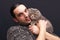 Portrait of brunette man holding face to face a gray hair Scottish Fold yellow-eyed male cat