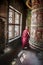 Portrait of a buddhist monk turning a huge prayer wheel in Nepal.