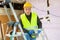 Portrait of builder handyman working with electric drill in repairable room