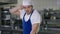 Portrait of burnt out Caucasian handsome bearded young man in cook uniform sighing rubbing forehead standing in